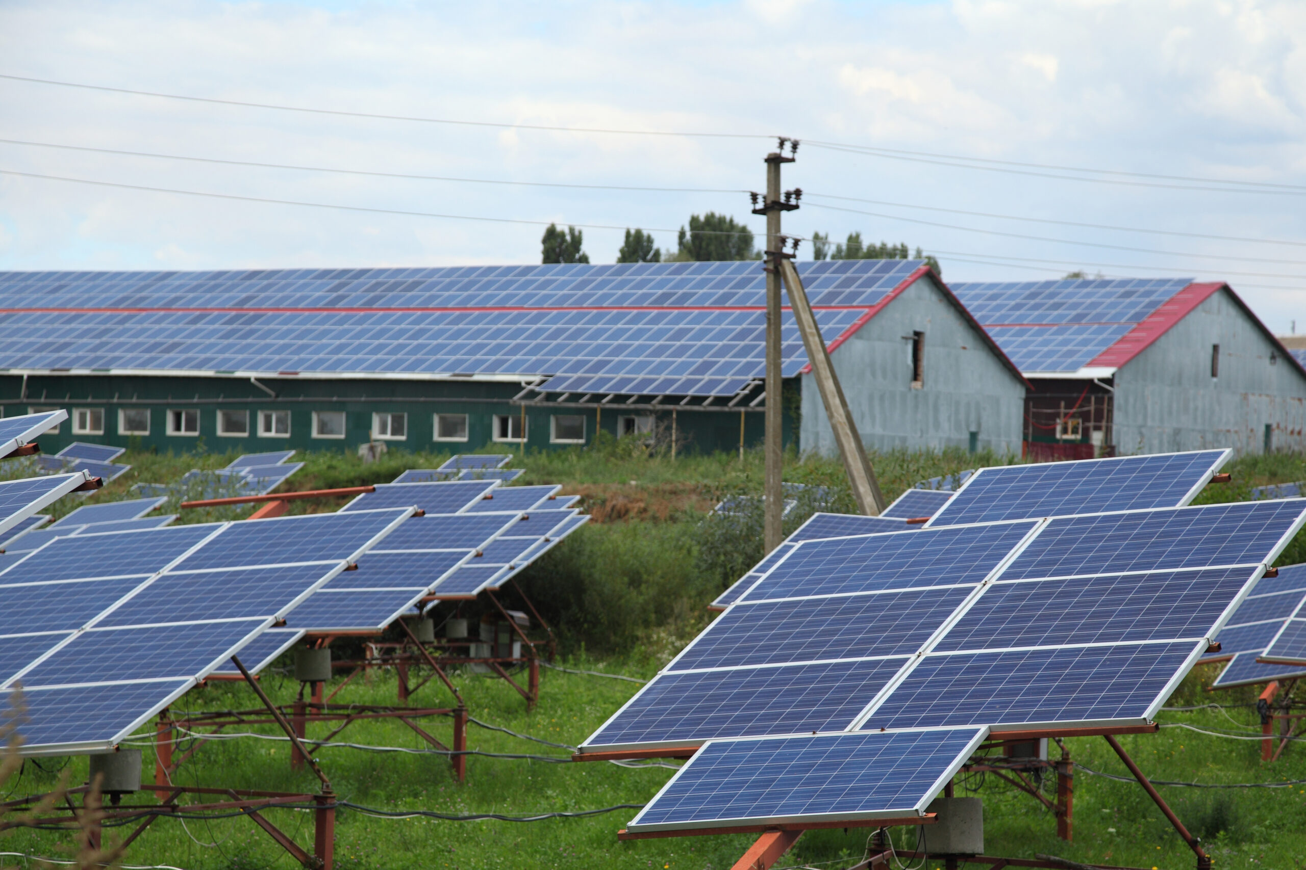 Ground-based and barn rooftop solar panels in a rural context.